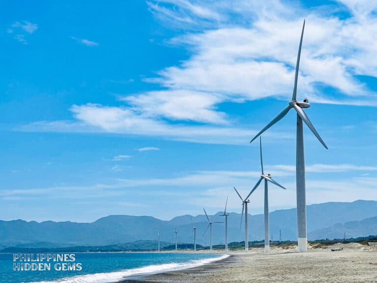 Windmills lined up at the shore with white sand in Ilocos Norte.
