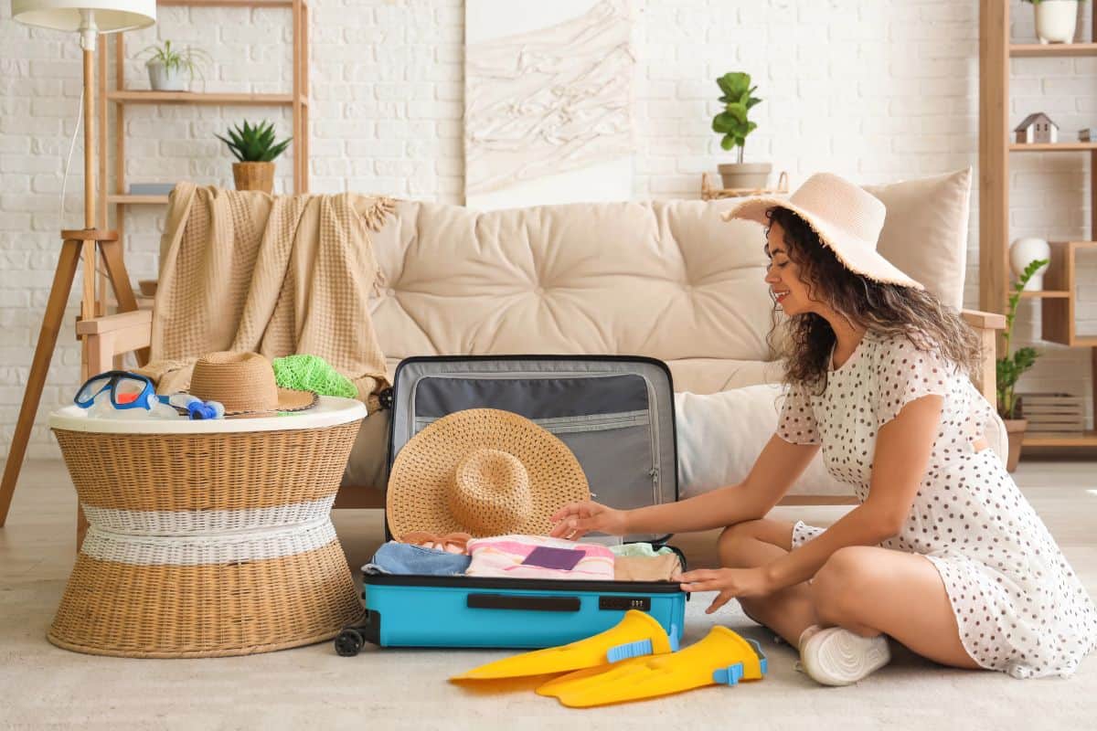 Woman packing a suitcase with summer essentials, getting ready for a tropical trip and trying to avoid costly mistakes when you explore the Philippines sustainably and visit hidden gems.