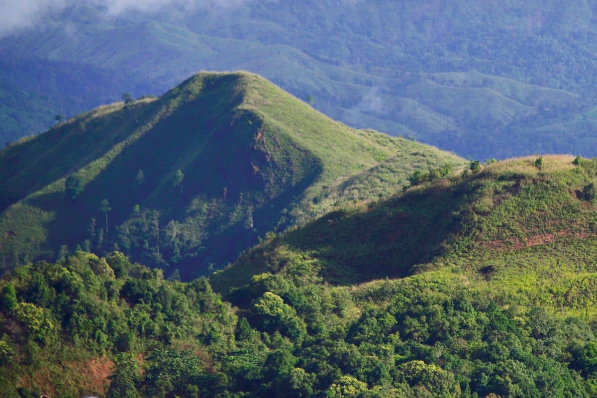 Lush green mountain peaks along one of the scenic Philippine Trekking Routes, offering panoramic views and trails through untouched landscapes.