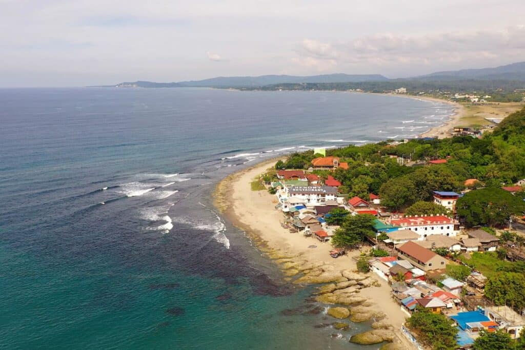 Surfers riding waves at Urbiztondo Beach in La Union, a popular spot for weekend travelers