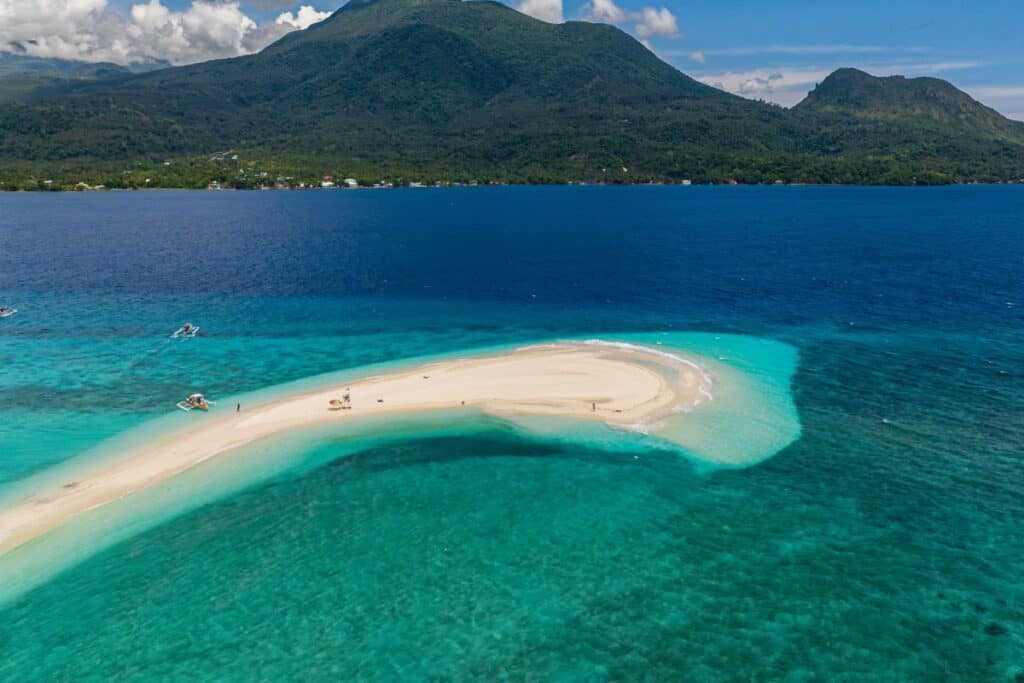 Pristine white sand beach with turquoise waters in Philippines Hidden Gems destination.
