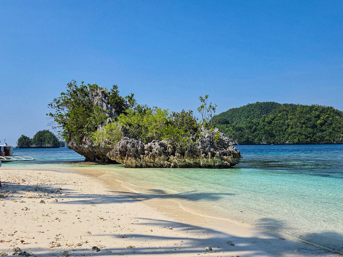 A beautiful beach on a sunny day with views of the surrounding islets.