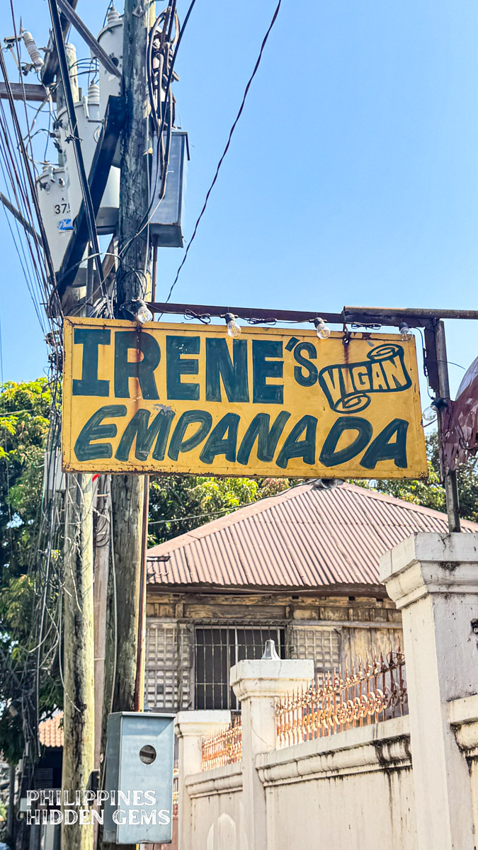 A yellow store sign that says "Irene's Vigan Empanada".