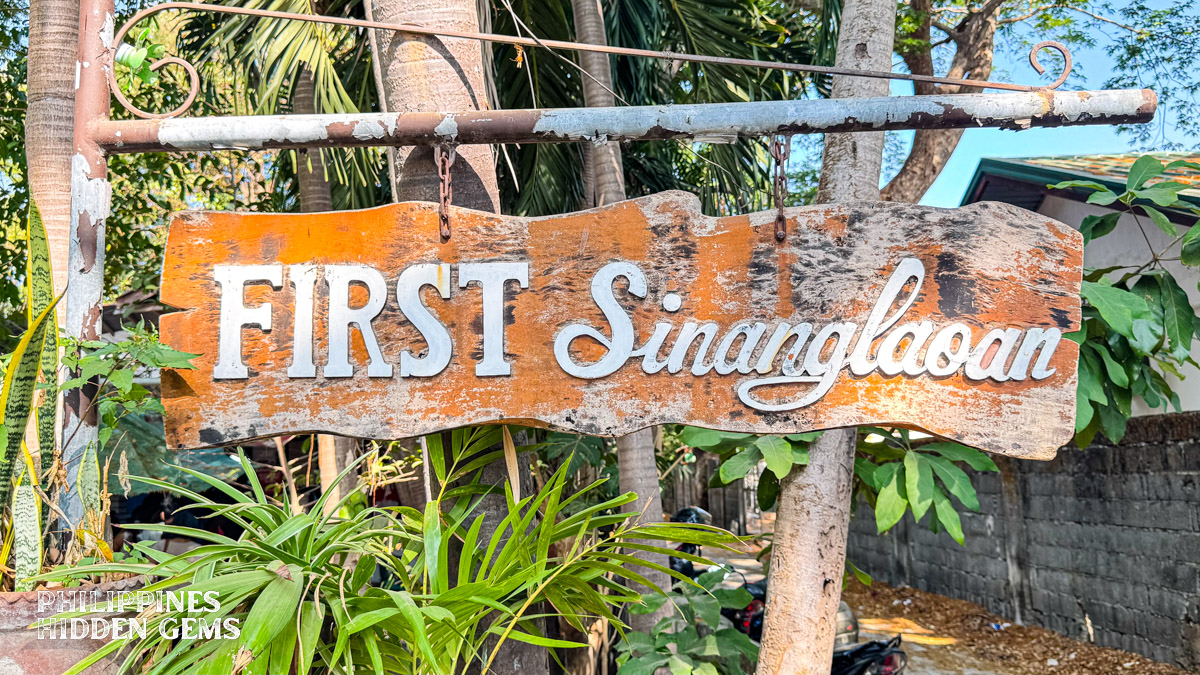 A wooden sign that says "FIRST Sinanglaoan".
