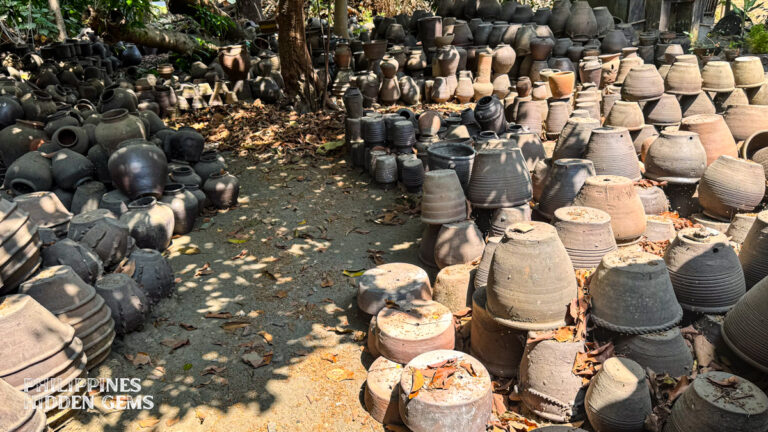 Pottery in Vigan Pagburnay jars displayed outdoors.