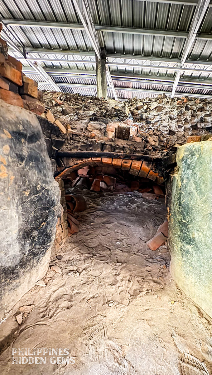 The opening of a pottery kiln full of ashes.