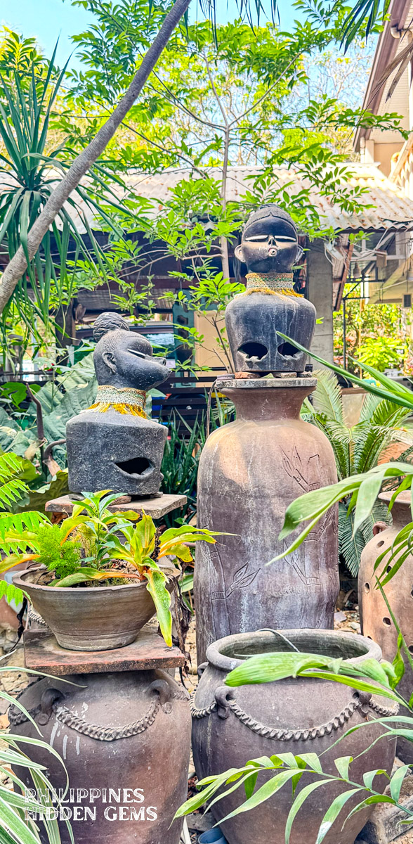 Pieces of pottery vases and figures at an outdoor garden.