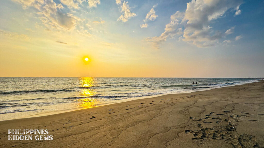 Sunset that casts a golden light in the sky at the beach.
