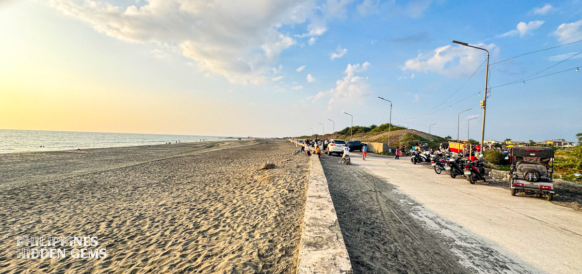 The road near the beach full of vehicles.